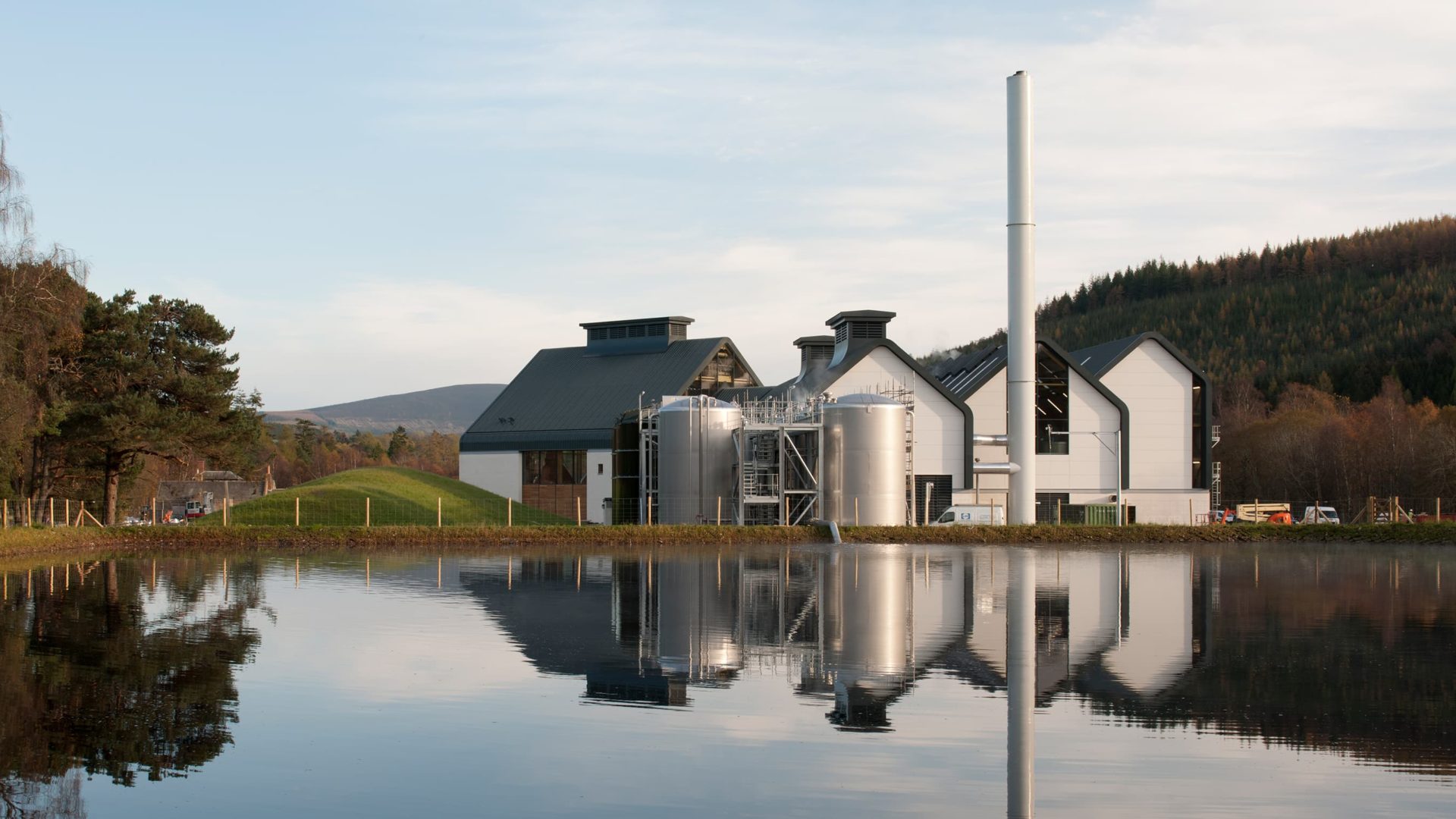 back view of dalmunach distillery building exterior with lake