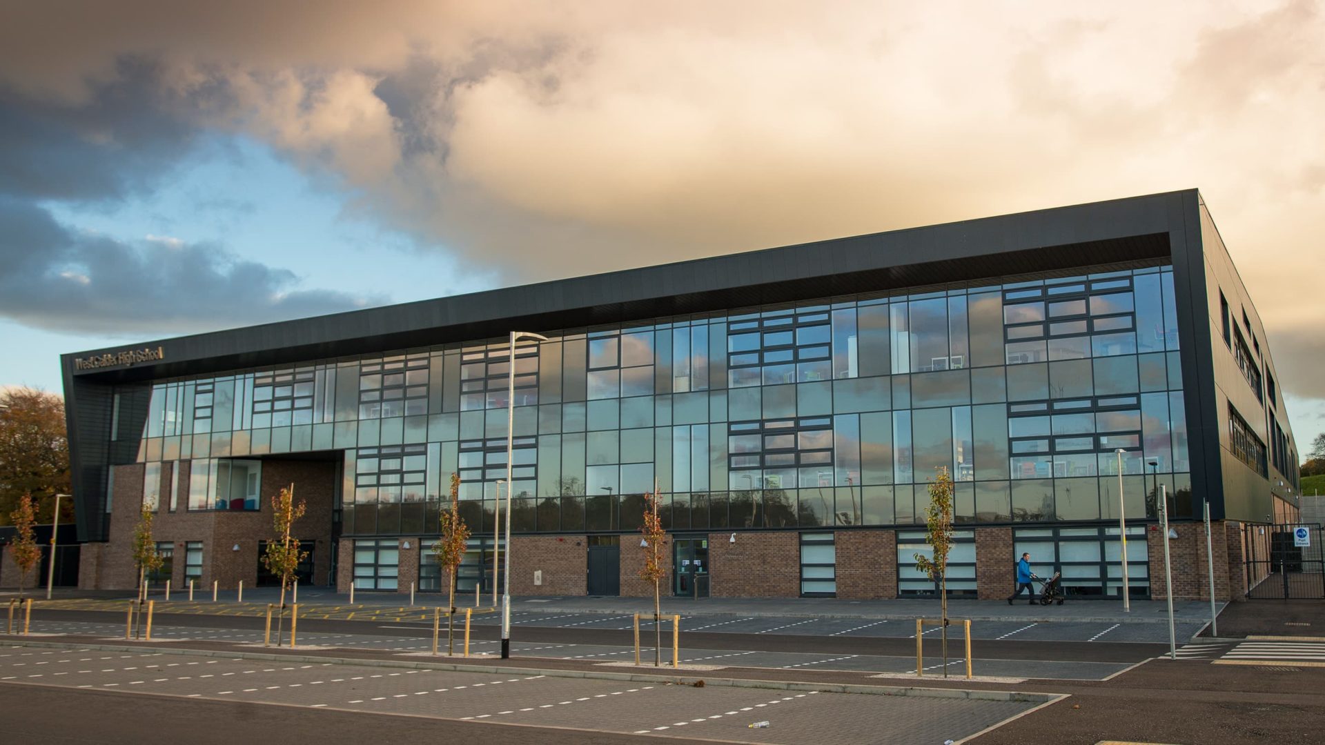 exterior of west calder high school at dawn. brick building with large windows