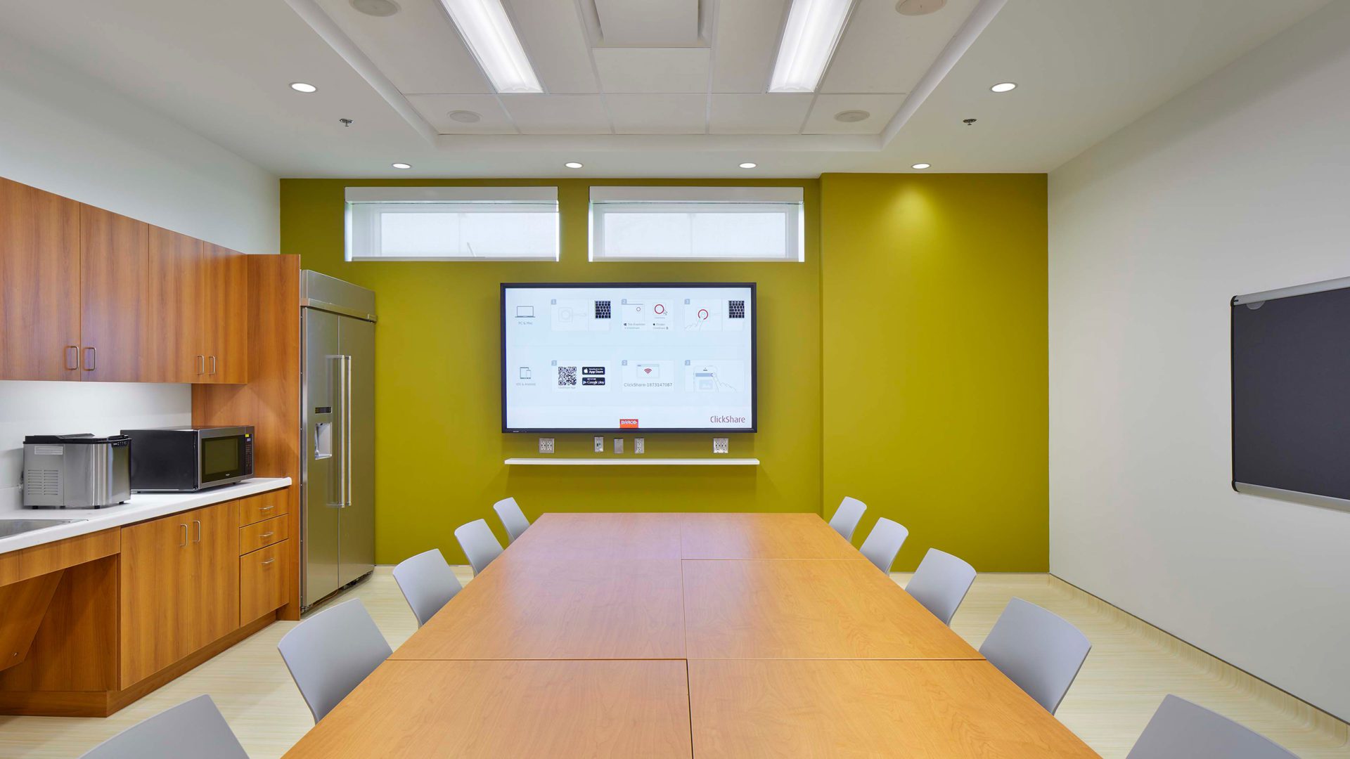 meeting room interior with green walls and long wood conference table