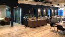 reception area with dark walls and wood desks and tables