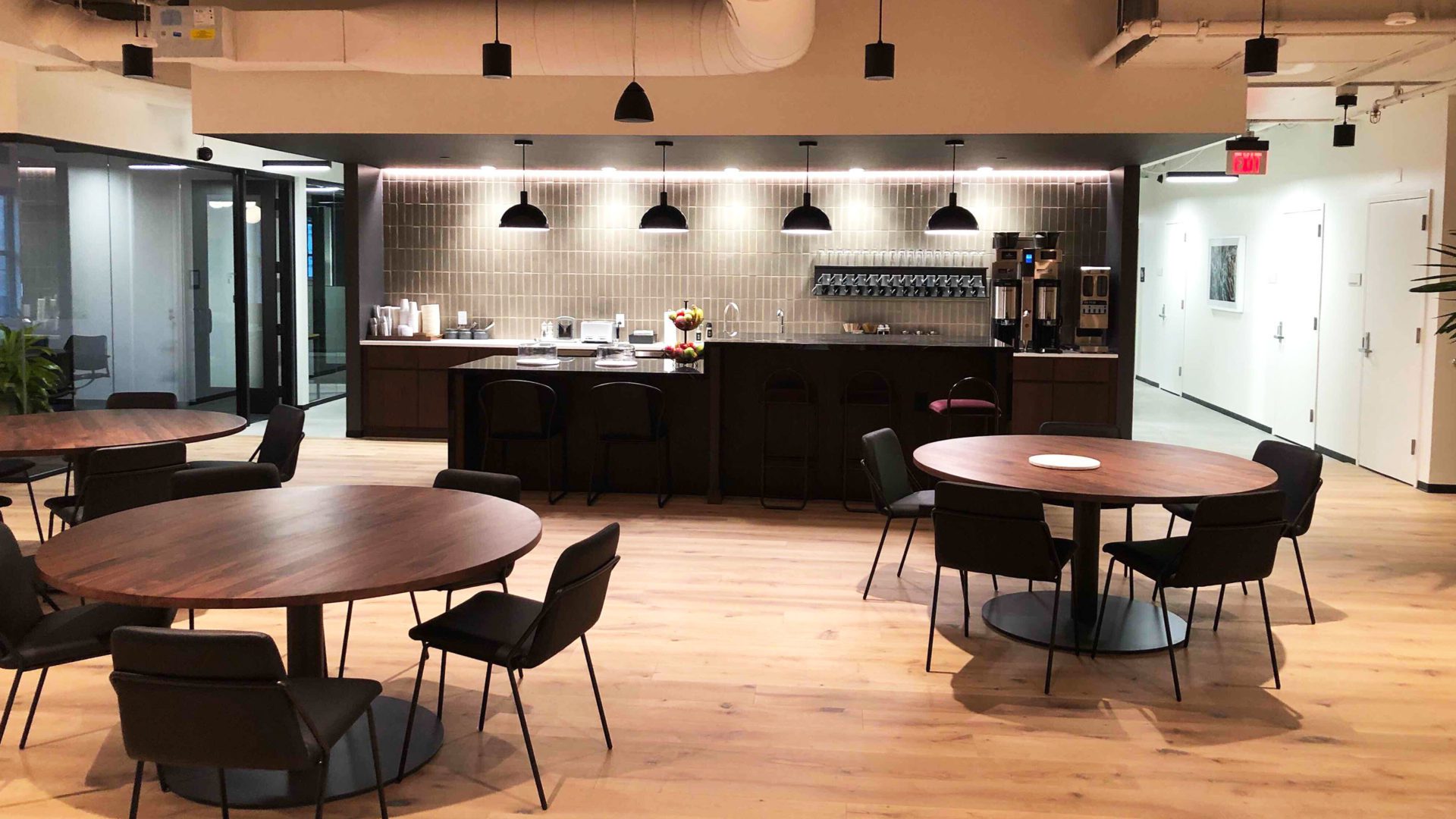 spacious office setting with numerous tables and chairs filling the room