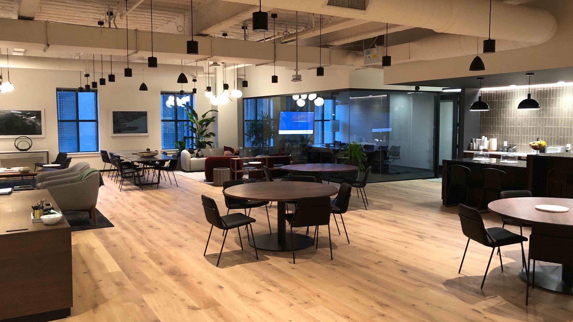 spacious office setting with numerous tables and chairs filling the room