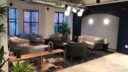 a spacious lounge area with comfy couches. large windows seen at the far left wall