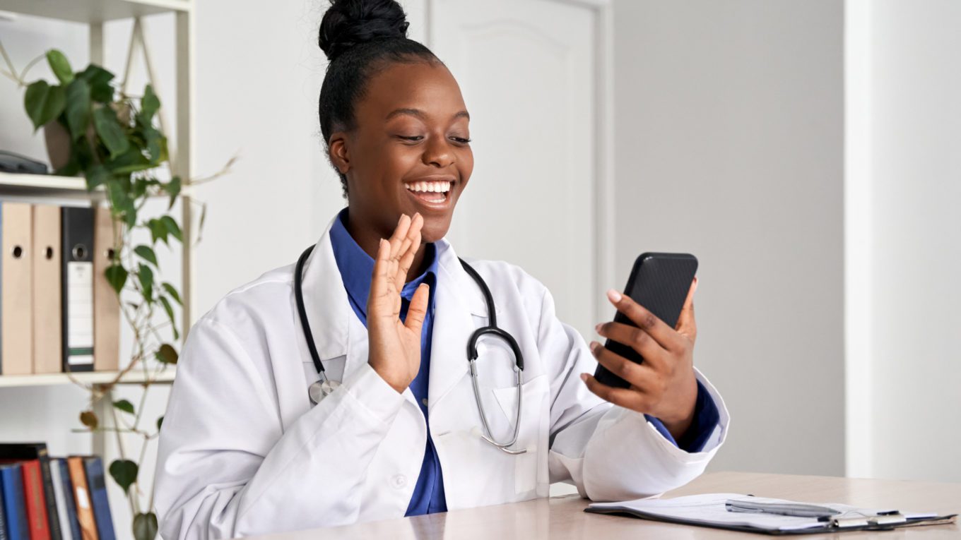 doctor waving to patient in a telehealth meeting