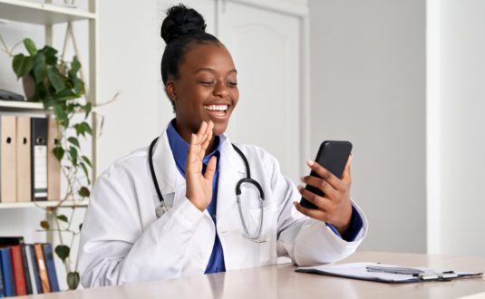 doctor waving to patient in a telehealth meeting