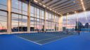 interior tennis court with floor to ceiling windows at 10XTO Athletic Club Tennis Court