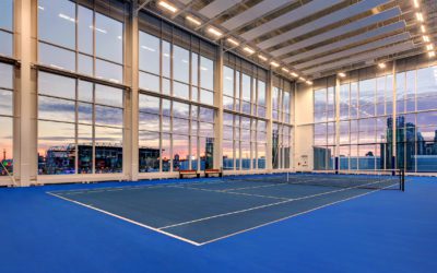 interior tennis court with floor to ceiling windows at 10XTO Athletic Club Tennis Court