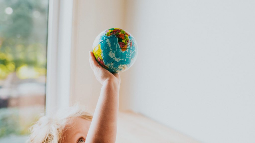 a child holding a small globe