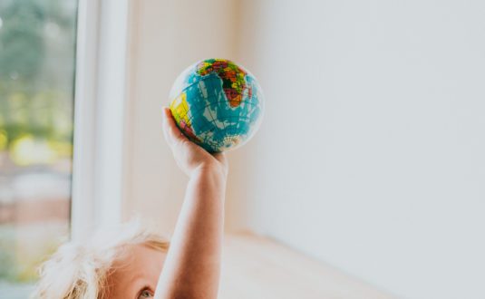 a child holding a small globe
