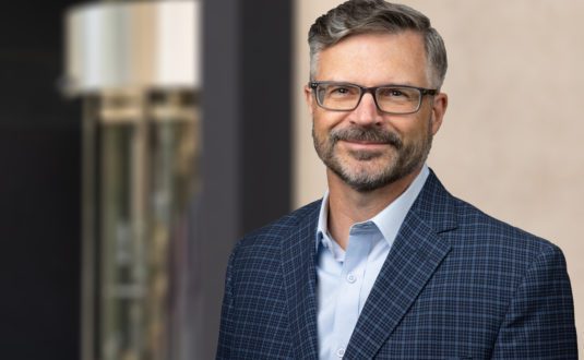 Insitu image of Ross Roy, Principal, Residential, Canada, He is standing, smiling in front of a commercial building