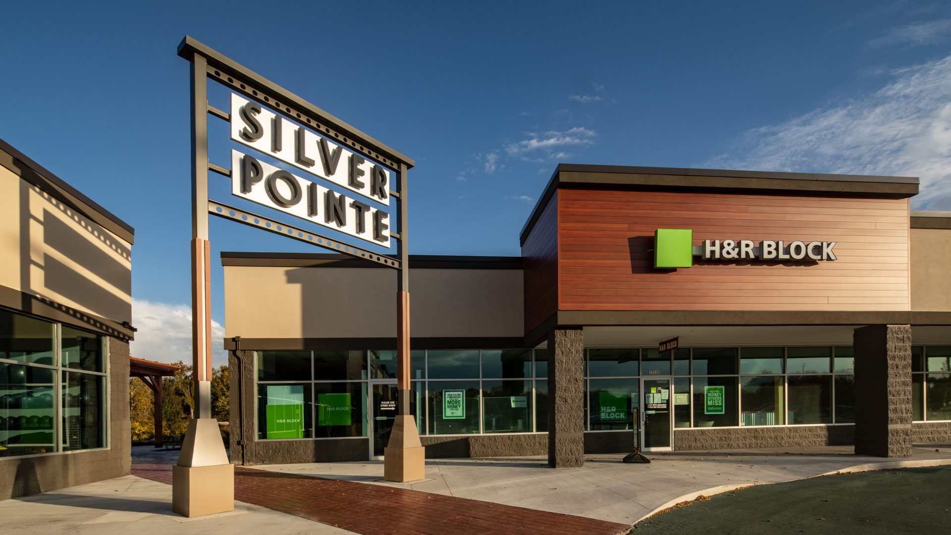 Silver Pointe Shopping Center Exterior. Brick plaza with tall sign that says Silver Pointe Shopping Center and another saying H&R Block