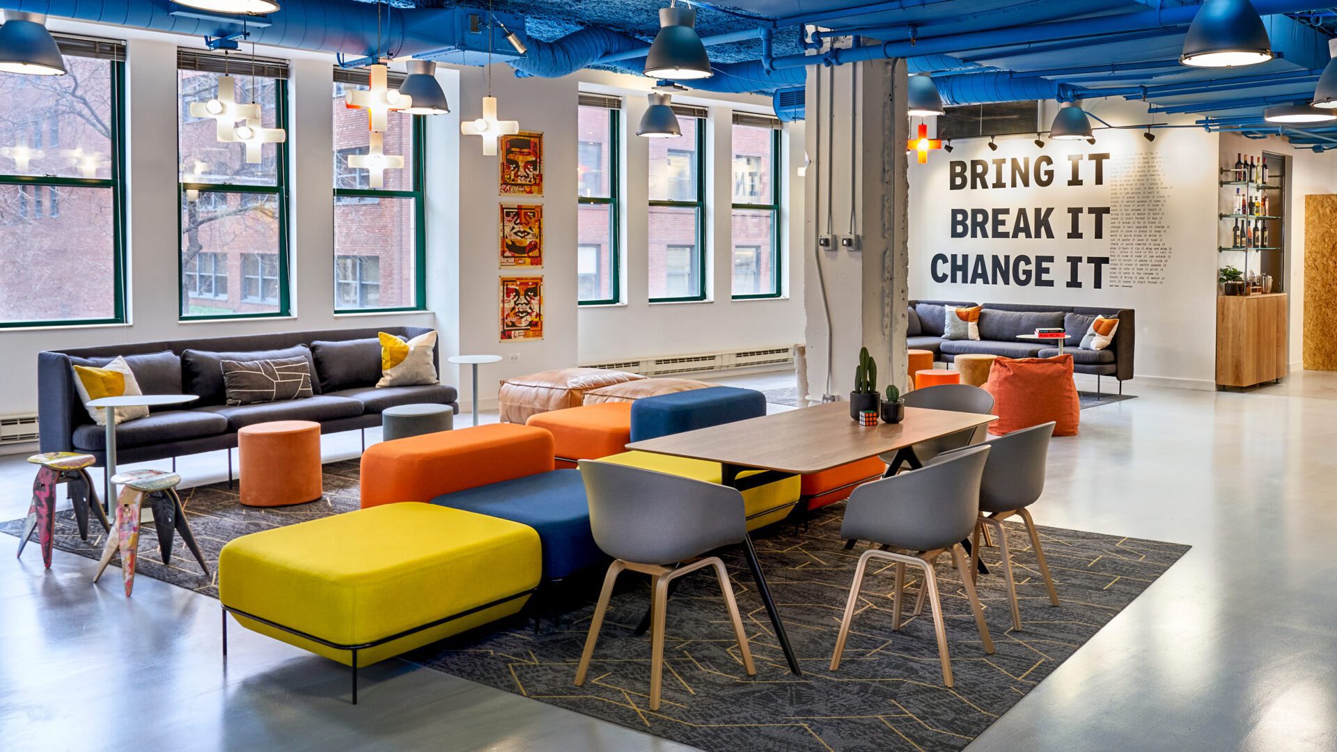 Seating area with bright colors. "Bring. Break it. Change it." is written on wall.