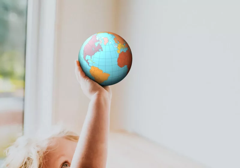 Child holding globe facing pacific side