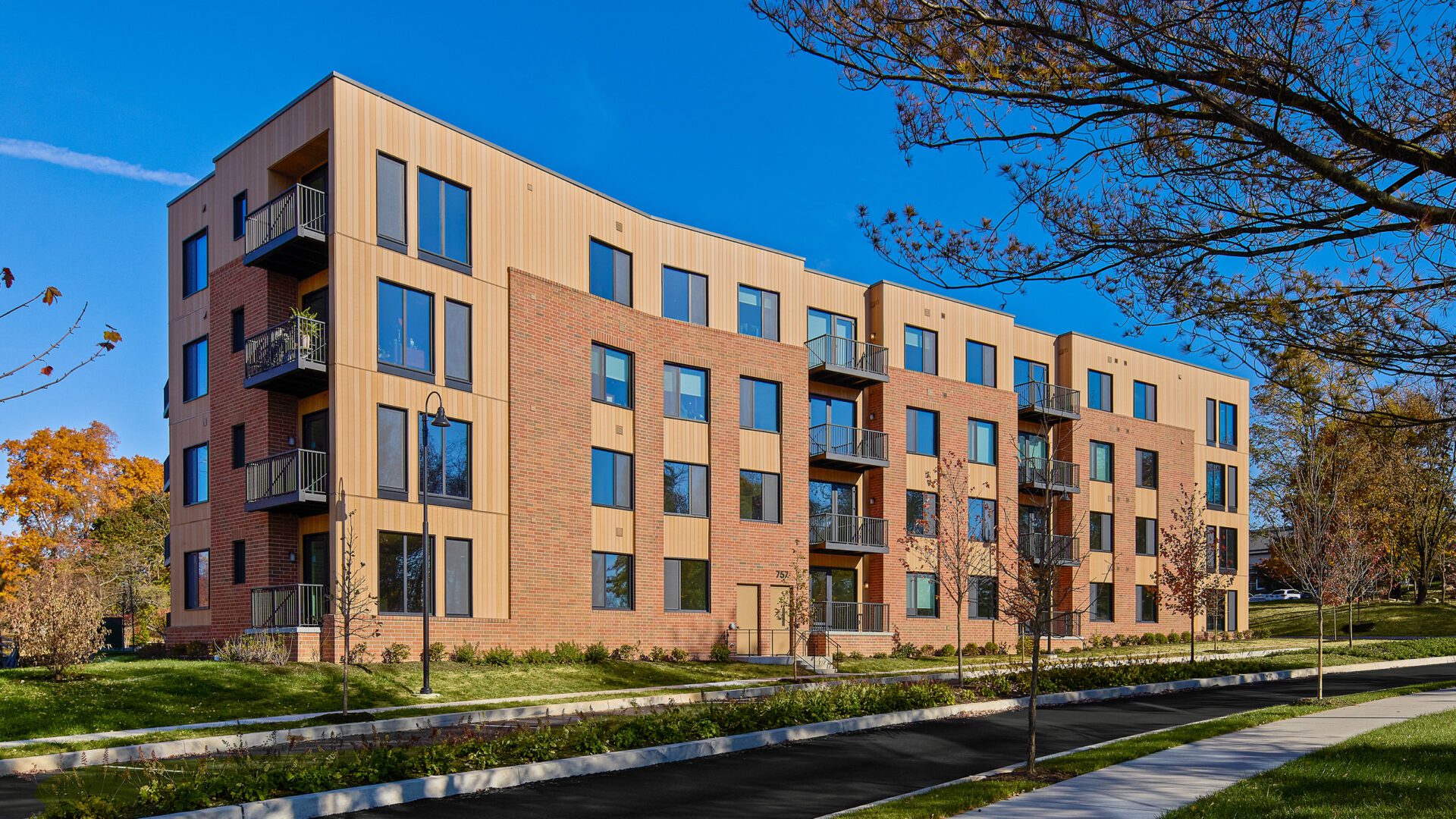 A stylish apartment building showcasing contemporary architecture, landscaped surroundings and pedestrian-friendly pathways.