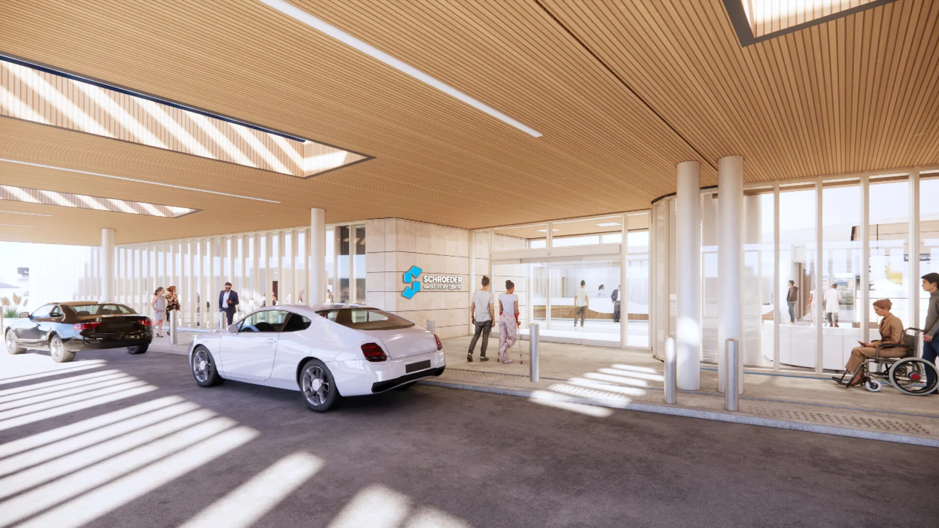 The entrance area of the Schroeder Ambulatory Centre with a paneled ceiling, glass walls and people walking or being dropped off in cars. A welcoming and accessible design.