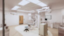 A clean and well-equipped medical room featuring advanced equipment and surgical lighting ready for medical procedures.