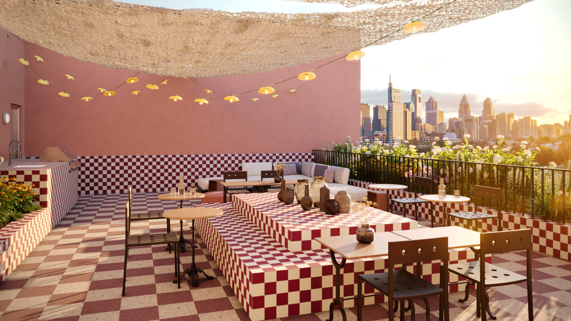 A rooftop terrace with a checkerboard design in red and white tiles. The space includes tables, seating areas, string lights and a panoramic view of the city skyline at sunset.