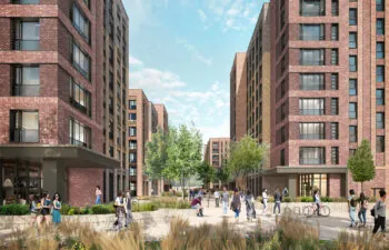An urban courtyard surrounded by mid-rise brick buildings, with people walking, biking, and sitting among landscaped greenery.