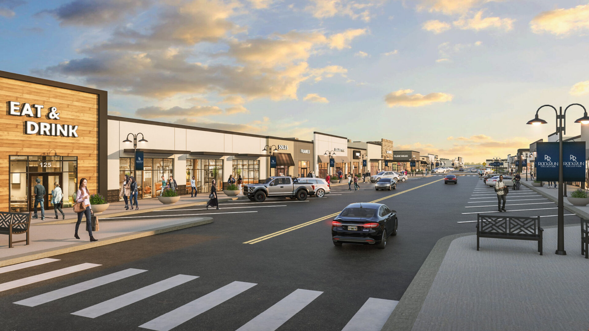 Retail street at Rock Run Collection with storefronts, sidewalks, seating, and crosswalks.